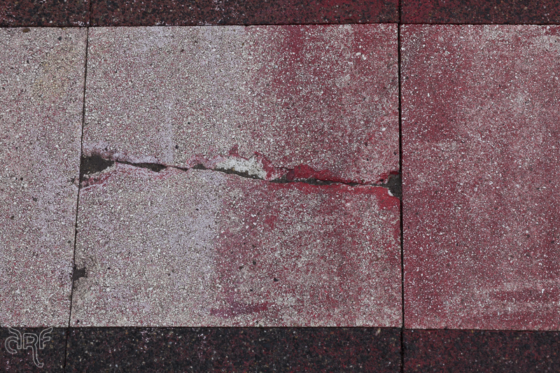 faded red paint on sidewalk