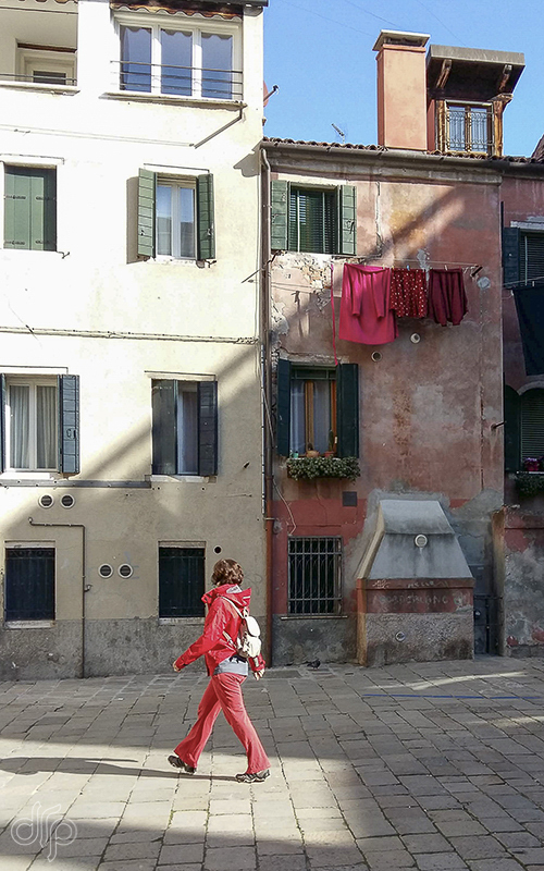red laundry and lady in red in front of a red house in Venice, Italy