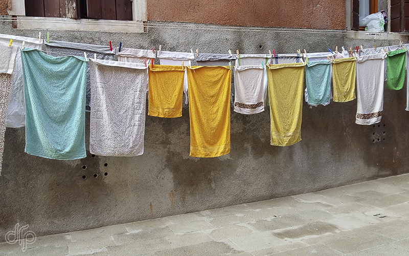 yellow and white laundry in front of a house in Venice, Italy