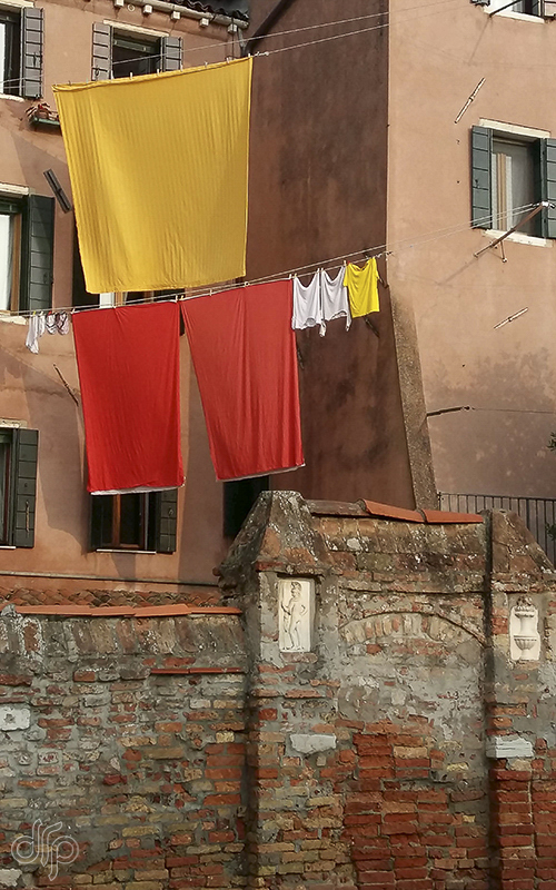 yellow and orange laundry at terracotta house in Venice, Italy