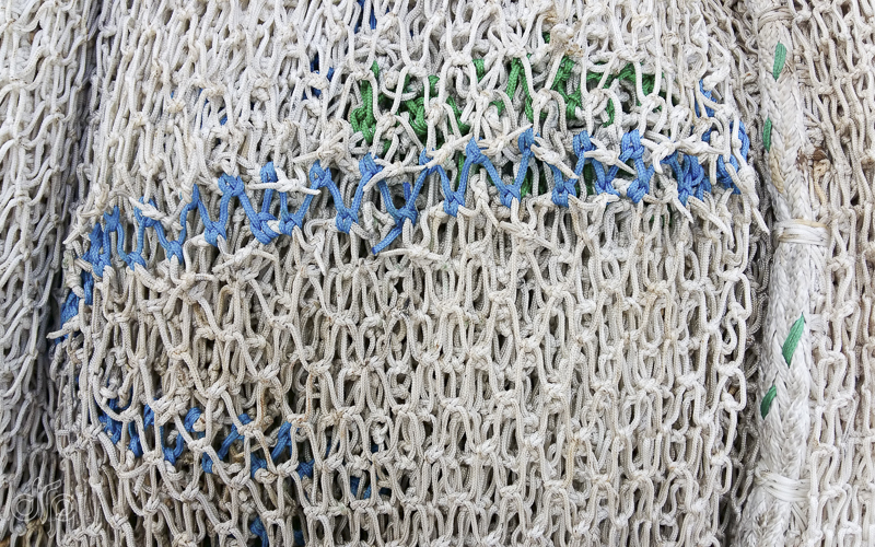 visible mended fishing nets with blue and green
