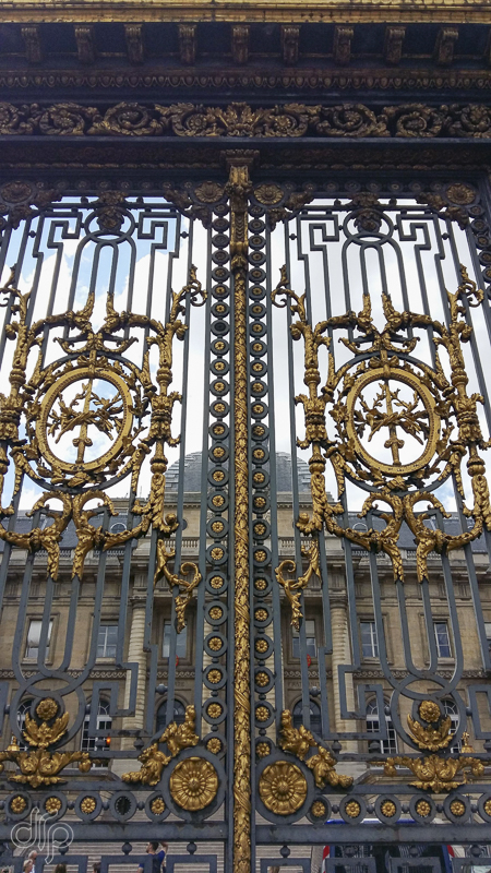 Intricate golden fence of l'Horlogerie, Paris
