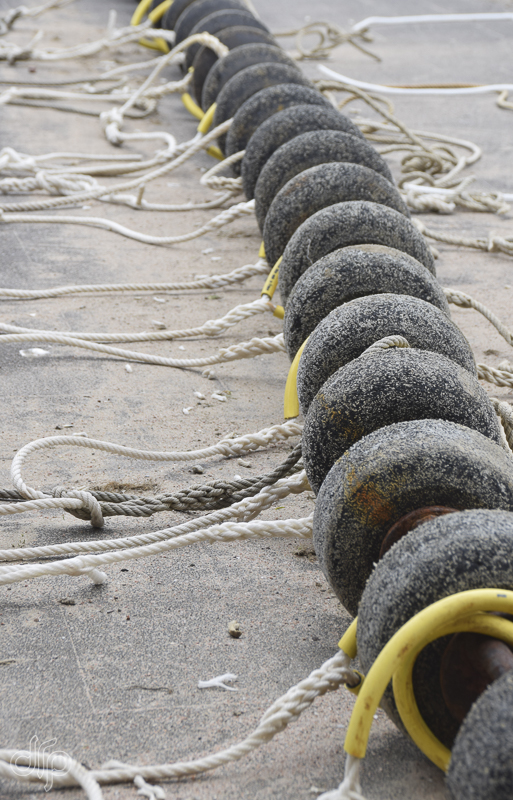 a row of rubber balls with ropes and yellow tubes