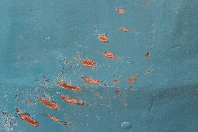 teal surface with rusty dots