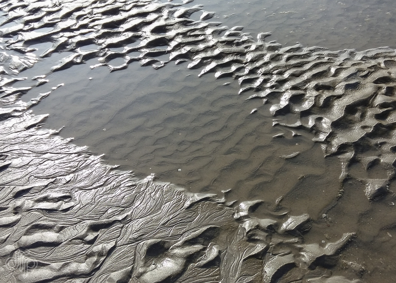 wavy sand pattern and puddle