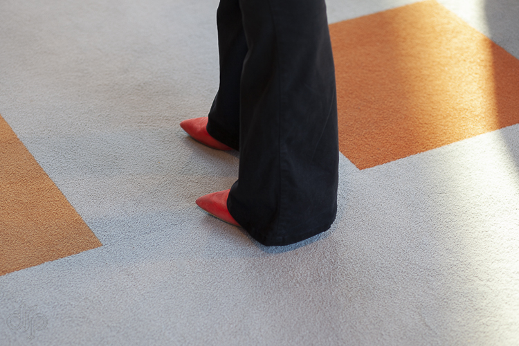 Red shoes on a grey-orange carpet