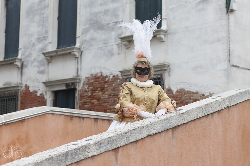 The character of Silvia from Commedia dell Arte posing on a bridge in Venice, Italy