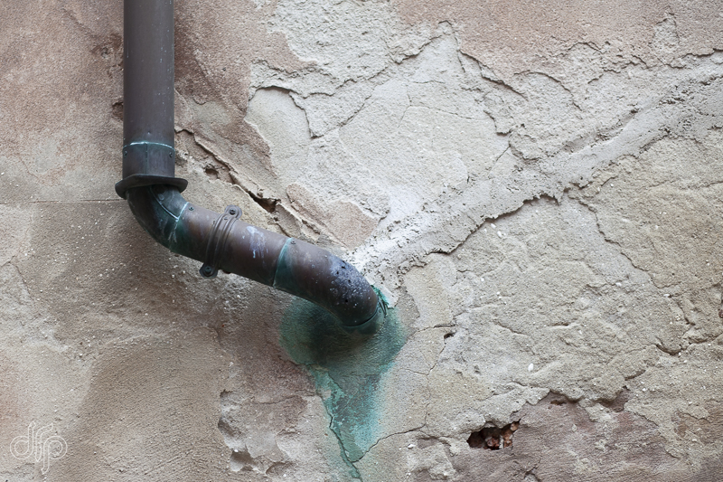Copper downspout with green traces on wall in Venice Italy