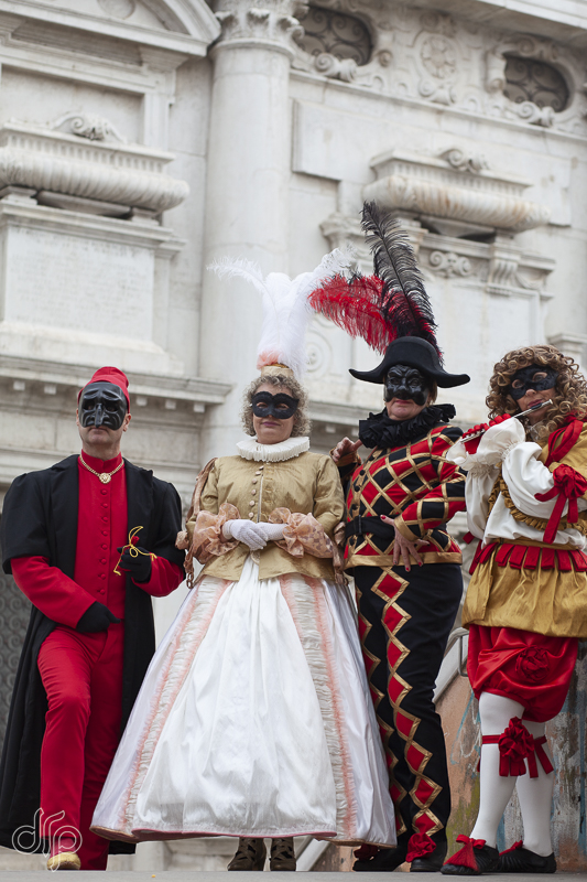 Four characters of Commedia dell'Arte posing on a bridge in Venice, Italy.