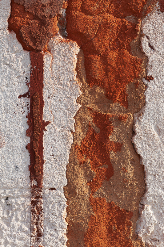 Warm orange and rusty coloured textured wall in Venice, Italy