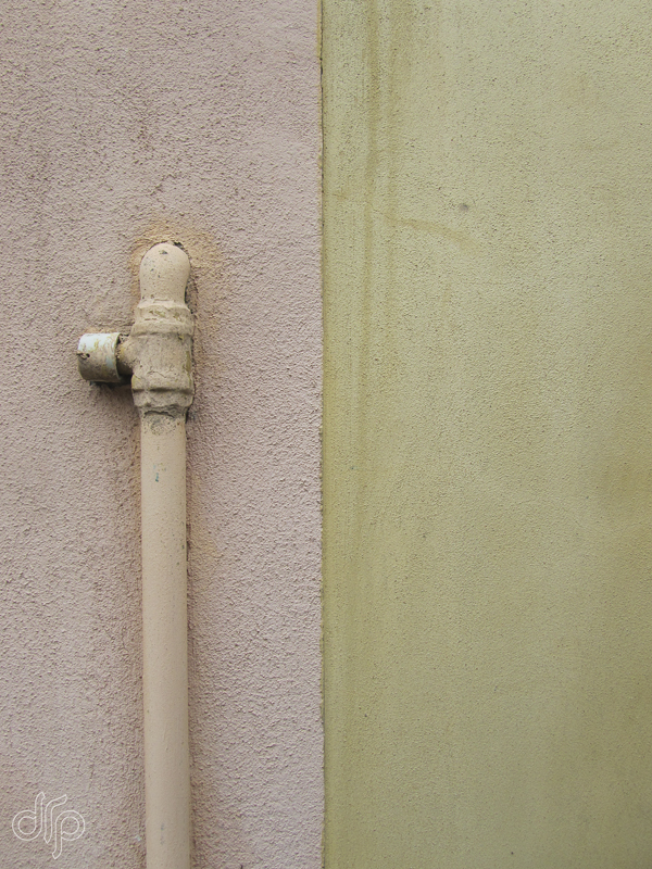 Yellow and salmon coloured wall abstract with down-spout in Venice, Italy